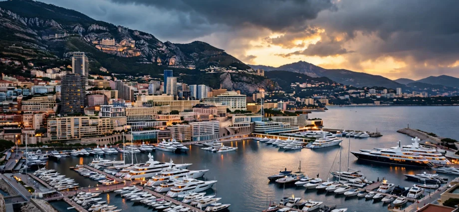 Monaco harbour at dusk with luxury yachts and the Monte Carlo skyline